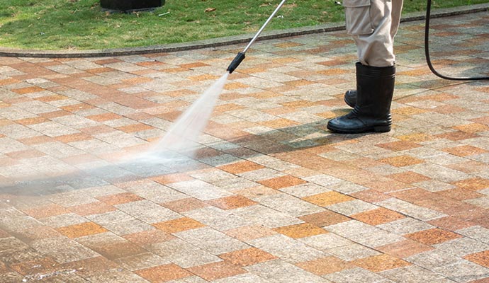 a professional providing pressure washing service using equipment