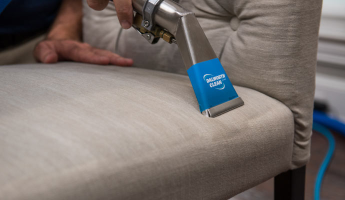 A Professional cleaning a chair using equipment