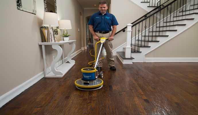 Person cleaning wooden floor Person cleaning wooden floor with equipment