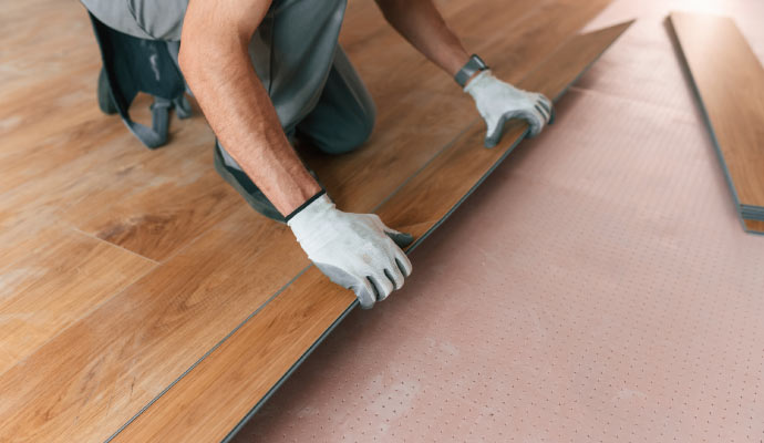 Professional worker installing new wooden floor