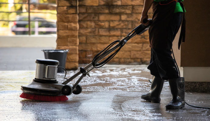 professional worker cleaning concrete floor