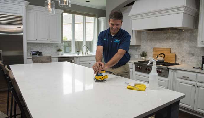 A countertop is being cleaned by a professional cleaner