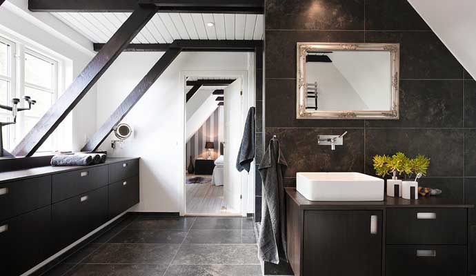 A modern bathroom with dark stone tiles on the floor