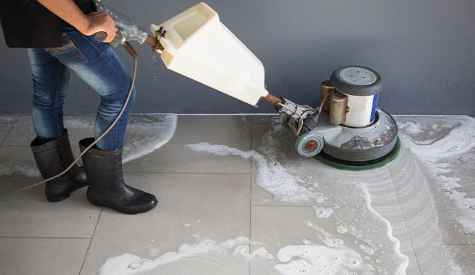 Cleaning tile floor with equipment Person cleaning tile floor with equipment